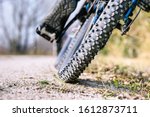 Mountain bike tire low angle closeup on trail - Man cycling mtb outdoor back view of wheel on  gravel ground - Concept of sport bicycle activity and tyre performance - Image