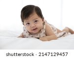 Small photo of cute baby crawling on bed and drooling from mouth