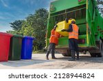 Teamwork garbage men working together on emptying dustbins for trash removal with truck loading waste and trash bin. Garbage collector.