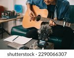 Small photo of Artist composer in work process, A songwriter or composer, songwriter thinking and writing notes, lyrics in book. man playing live acoustic guitar.concept for musician creative.