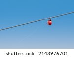 Small photo of A fishing bobber tangled around a power line