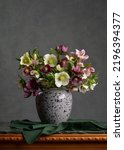 Small photo of A motley bouquet of spring flowers in a gray earthenware jug. A vase on a green marble table. Dark gray background. Multicolor. Calm still life. Relax. Comfort at home.