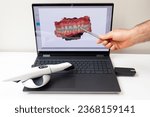 Small photo of Dentist Shows 3D Scanned Picture of Scanned Teeth on Monitor of Computer, White 3d Intraoral Dental Tooth Scanner Lying on Table. Dental Equipment, Device For Scanning Teeth. Dentistry. Horizontal