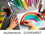 POV child painting a picture with school supplies, preschool child painting, child drawing a rainbow, child doing homework.