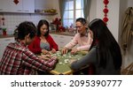 Small photo of asian family of four shuffling tiles while playing together on chinese new year eve at home. chinese word at background translation: luck