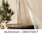 Small photo of Natural wooden table and organic cloth with olive tree plant. Product placement mockup design background. Outdoor tropical summer scene with rustic vintage countertop display