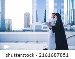 Small photo of Arab couples or colleagues working together on tablet or laptop wearing traditional clothes and abaya. Muslim employees Saudi or Emirati business woman and man