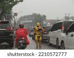 Small photo of jakarta,indonesia-october 2022:a busker is following an iron man costume in the middle of the road