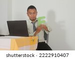 Small photo of a cool Indonesian teacher is teaching online, explaining learning letters, mentioning the letter F to his students on a laptop