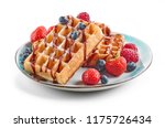 plate of waffles decorated with chocolat sauce and fresh berries isolated on white background