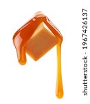 Small photo of caramel sauce flowing on flying caramel candy isolated on white background