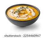 vegetable cream soup decorated with chili flakes and thyme isolated on white background