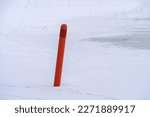 Small photo of Red navigational spar buoy on a frozen lake in Hollola, Finland