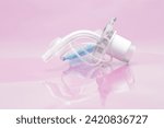 Small photo of Medical and healthcare concept. Disposable tracheostomy tube with cuff, cuff inflation line and balloon for establishment of artificial airway and breathing support on light background