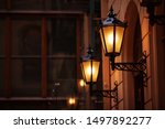 Old fashioned street lamp at night. Brightly lit street lamps at sunset. Decorative lamps. Magic lamp with a warm yellow light in the city twilight. Copy space