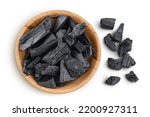 Natural charcoal in wooden bowl isolated on white background with full depth of field. Top view. Flat lay