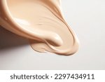 Small photo of Liquid foundation strokes on light color background, Makeup creamy texture, Skin tone cosmetic product smear smudge swatch