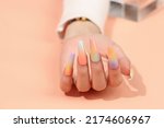 Beautiful female hands with fashion manicure nails, white gel polish, heart design, on pink background with place for text