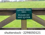 Conservation area, please do not enter sign on a wooden gate.
