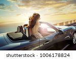 
happy young woman enjoying a ride in a convertible car 