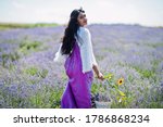 Beautiful indian girl wear saree india traditional dress in purple lavender field. 