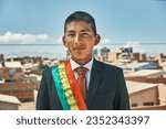 Small photo of young latin bolivian flag bearer with the bolivian flag in black suit