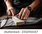 Man sharpening knifes with special stone tool, closeup view