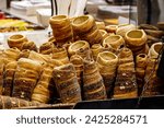Trdelník - Kürtőskalács - Chimney cake - Spit cake. Window display of fresh products. Popular cake made with layers of dough deposited onto rotating spit. Pastry popular in central european countries.
