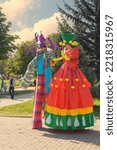 Small photo of Almaty, Kazakhstan - September 18, 2022. guy and a girl in national Kazakh costumes stand on stilts and greet the townspeople at a holiday in the park