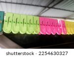 Light green, pink and yellow plastic  pegs on a clothing line