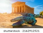 Small photo of Bronze statue of Icarus in front of the Temple of Concordia at the Valley of the Temples. Temple of Concordia and the statue of Fallen Icarus, in the Valley of the Temples, Agrigento, Sicily, Italy.