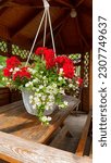 Small photo of White and red small flowers in white hanging pot. Lush bloom. Wood alcove, cosines. white allisum (lobularia), red balsamin. decorating a balcony, a plot, caring for a personal plot