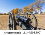 An old fashioned cannon sits in front of changing trees at Fort Laramie in Wyoming during the autumn