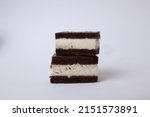 Two pieces on top of each other from a side of Kinder milk slice on a white background cake bottom with milk vanilla mousse