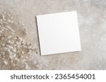 Small photo of Blank wedding invitation, flyer or greeting card mockup on trendy beige background, white card mock up with copy space