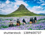 Tourist ride horse at Kirkjufell mountain landscape and waterfall in Iceland summer. Kirjufell is the beautiful landmark and the most photographed destination which attracts people to visit Iceland.