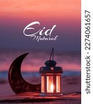 Small photo of Lantern lamp with Crescent moon shape on the beach with sunset sky, 2024 Eid Mubarak greeting background