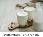 Small photo of Kefir, buttermilk or yogurt with probiotics. Yogurt in glass on white wooden background. Probiotic cold fermented dairy drink. Gut health, fermented products, healthy gut flora concept. Copy space