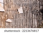 Small photo of A layer of cane, formerly used as a layer for plaster (Roughcast) on the wall. Old, historic house. Damaged wall with broken plaster and an exposed layer of cane.