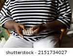 Small photo of Black woman holds progesterone pills, modern hormone replacement therapy for the treatment of menopause and menopausal symptoms