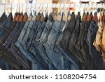 Many jeans hanging on a rack....