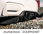 Quad tip exhaust pipe with a carbon fiber rear diffuser on a white car