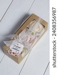 Small photo of Box with homemade marshmallows. It is tied with tape. The branded tag of the entrepreneur is visible. Zephyr flowers. Roses from zephyr. A unique gift.