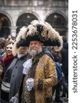 Small photo of Venice, Italy - 02.19.2022 - Bearded gray-haired senior man in a big carnival tricorn hat and medieval costume at the carnival in Venice