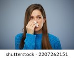 Woman blows his runny nose in napkin. Isolated female portrait healthcare and medical concept.