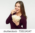 Beautiful woman with long hair eating pop corn. Isolated studio portrait.