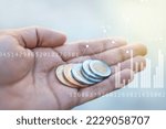 Small photo of Design of a hand of a young thin man holding with his palm Mexican coins of ten pesos with numbers and economic statistics