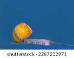 Yellow apple with measuring tape around it and blue background. health concept, healthy lifestyle concept.