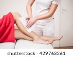 Beautician waxing woman a leg at salon / Depilation.