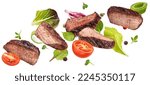 Small photo of Falling steak salad ingredients isolated on white background, sliced beefsteak, food packaging concept